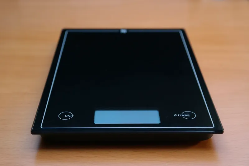 A flat digital kitchen scale on a countertop
