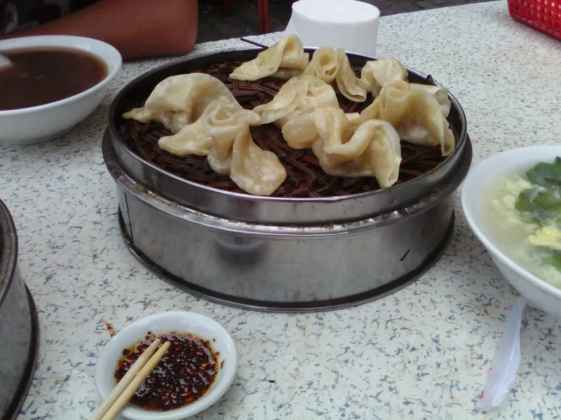 Steamed dumplings with a small dish of chili oil for dipping